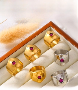 Detail of PVD electroplated gold and silver rings with red zircon in a display box