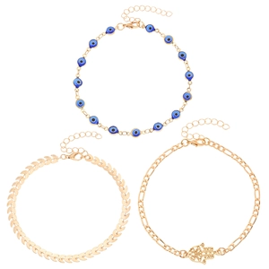 Detail of Hamsa Hand pendant and blue evil eye charms on vintage gold anklet set