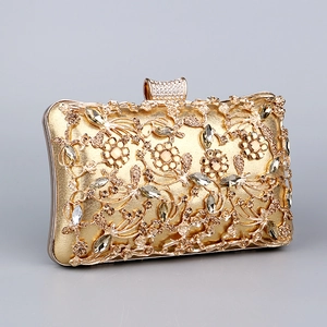 Detailed close-up of intricate hollow metal carving and sparkling rhinestones on gold evening bag
