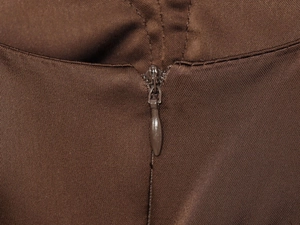 Dettaglio della cerniera invisibile su tessuto twill marrone per abito da donna