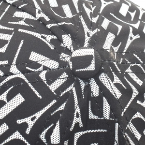 Détail macro du bouton supérieur et des coutures de la casquette avec imprimé lettres bicolore