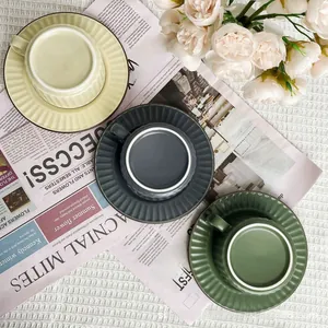 Detailed close-up of matte ceramic coffee cups with vertical pleated texture and saucers