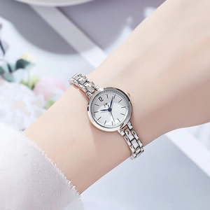 Elegant women's silver chain watch with white round dial and blue hands worn by model