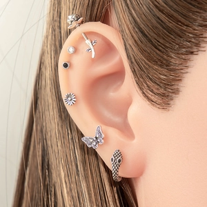 Silver titanium steel ear piercing set with butterfly rose and snake designs on model