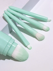 Detail of 5-in-1 mint green makeup brush set with gradient bristles on geometric props