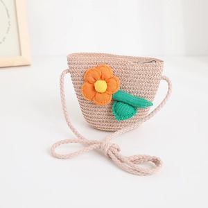 Detail of child straw crossbody bag with knitted orange flower and secure zipper