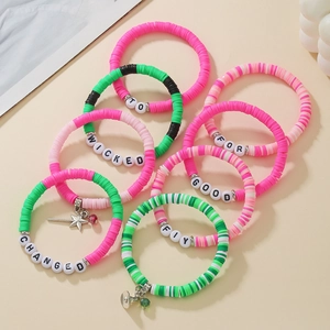 Detailed macro view of multi-layered heishi bead bracelets with wicked letter charms