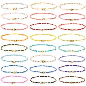Set of 24 colorful handmade bead bracelets with gold accents in a grid layout