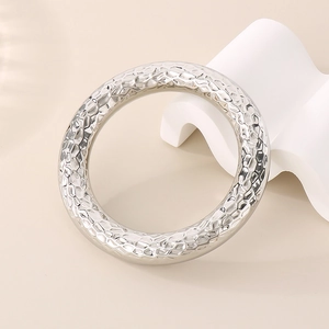 Detailed view of silver hammered texture on round stainless steel bangle jewelry