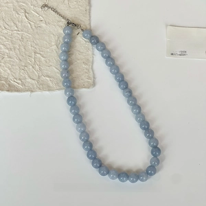 Détail macro d'un collier de perles en pierre naturelle aigue-marine avec fermoir argenté
