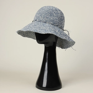 Detailed view of a handmade blue and white mixed knit sun hat with a wide brim on a display