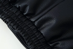 Detail of black leather jacket showing elasticated hem with high-quality pebble texture