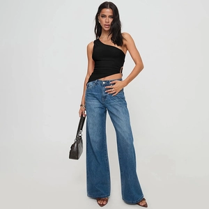 Full view of black one-shoulder slim fit top and blue wide-leg jeans on a female model
