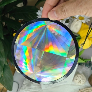 Close-up of holographic suncatcher with radial geometric pattern and black border
