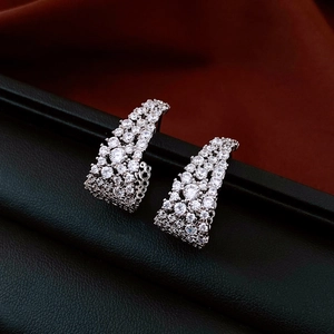 Détail macro de boucles d'oreilles en U en argent avec zircons sur cuir noir