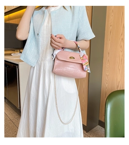 Pink crocodile pattern crossbody bag with gold chain and colorful silk scarf detail