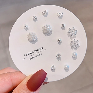 Detail of 14-piece silver stud earring set with pearls, snowflakes, and heart shapes