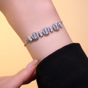 Elegant silver bracelet with geometric cubic zirconia stones on female model's wrist