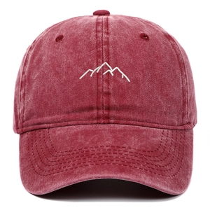 Detailed close-up of mountain embroidery on washed cotton burgundy baseball cap