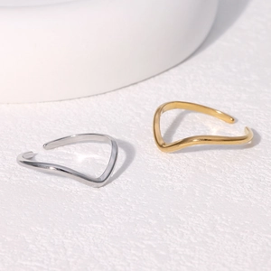 Minimalist stainless steel wavy open rings in gold and silver finish on white background