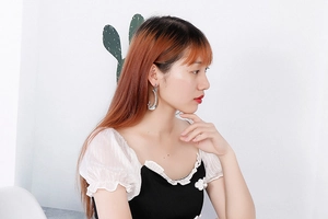 Détail de boucles d'oreilles lune et étoile argentées avec strass portées par un mannequin