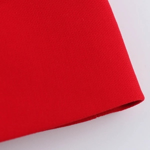 Macro shot of red knit fabric texture and bottom hem detail for women sleeveless vest