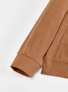Detailed macro view of the brown corduroy fabric texture with ribbed cuffs and hem