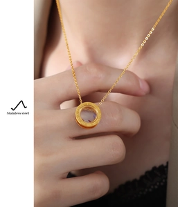 Macro shot of gold stainless steel necklace with Roman numerals and colorful stones