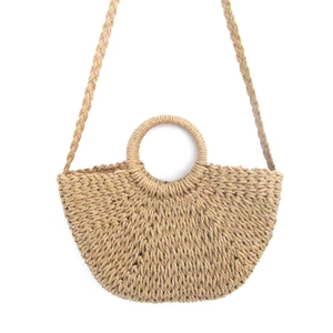 Detail view of woven paper straw bag with round handles and braided shoulder strap