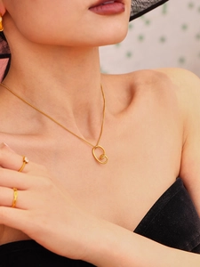 Detailed view of gold twisted knot pendant necklace and sparkling ring on model