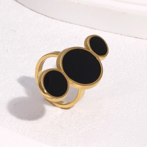Détail d'une bague en acier inoxydable doré 18 carats avec trois disques émaillés noirs
