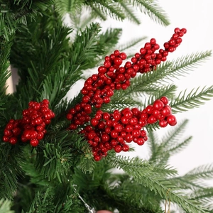 Macro shot of artificial pine branch with vibrant red holly berries for home decoration