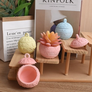 Detailed view of pastel relief storage jars with snowflake and berry leaf patterns