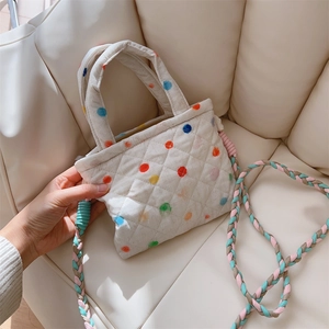 Detail of quilted floral phone bag with colorful polka dots and woven braided shoulder strap