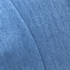 Macro detail of light blue denim fabric texture with visible diagonal twill weave