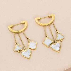 Macro detail of gold D-hoop earrings featuring shell-inlaid heart and flower charms