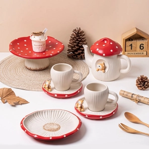 Detail of red mushroom ceramic tableware set with fox figurines and forest theme