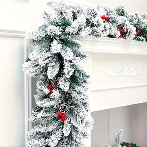 Detail of Christmas flocking garland with red berries and pine cones on a fireplace