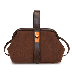 Close-up of retro dark brown shell bag featuring suede texture and gold metal clasp