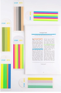 Flat lay of colorful PET long strip sticky notes and index tabs on an open book page