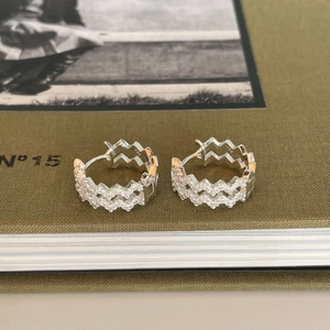 S925 sterling silver wave hoop earrings with pavé zircons on green book cover