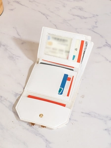 Detail showing the white tri-fold wallet's interior slots and card compartments