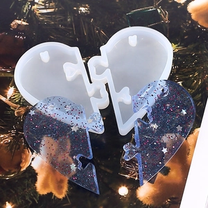 Macro view of heart-shaped puzzle silicone mold and blue glitter resin finished pendants