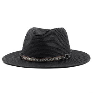 Détail d'un chapeau de paille noir avec ruban ethnique et rivets en métal argenté