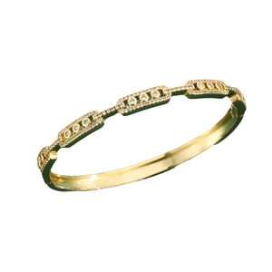 Luxurious gold geometric bangle with pave diamonds and dark green enamel accents
