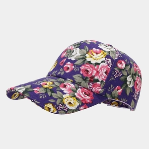 Detail of floral canvas baseball cap with pink and yellow rose pattern on purple fabric
