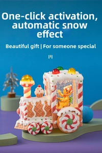 Close-up of lighted gingerbread train snow globe with auto-snow and candy details