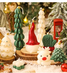 Mini Christmas tree and Santa gnome scented candles displayed on a snowy festive scene