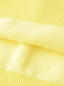 Close-up of bright yellow knit top showing vertical ribbed and textured grain patterns