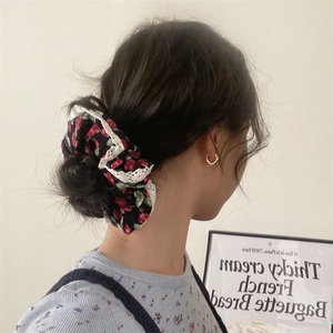Detail of floral lace scrunchie worn on a bun hairstyle for a French vintage look